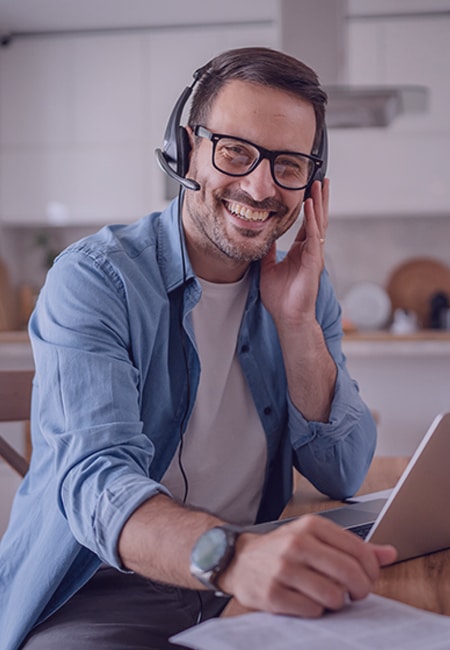 A man wearing headphones and working from home using laptop